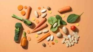 Flat-lay image showing Vitamin A-rich foods like carrots, sweet potatoes, and spinach alongside Vitamin A supplements and a warning icon, emphasizing the importance of moderation and balance.