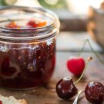 Cherry jam recipe in jar on rustic table