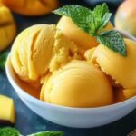 Mango sorbet scooped into tropical bowls