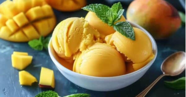 Mango sorbet scooped into tropical bowls