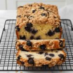 Moist sliced Blueberry Muffin Bread with crumb topping on cooling rack